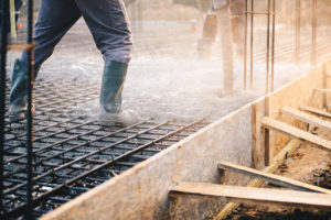 A construction worker prepares a grid of rebar for concrete 