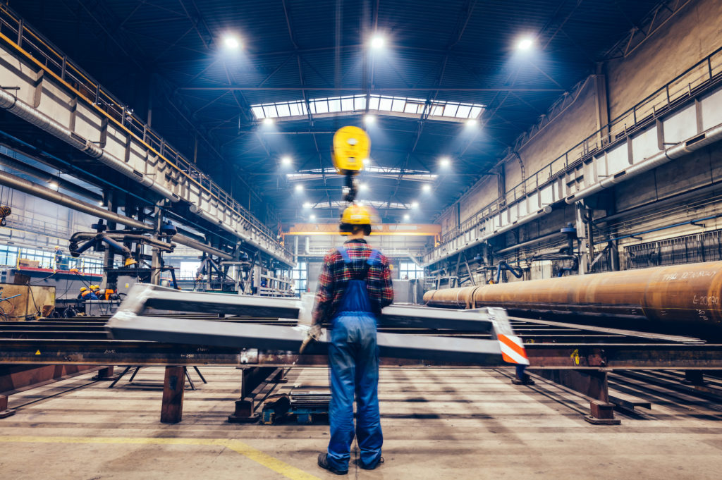 steel manufacturing plant with engineers wearing hardhats