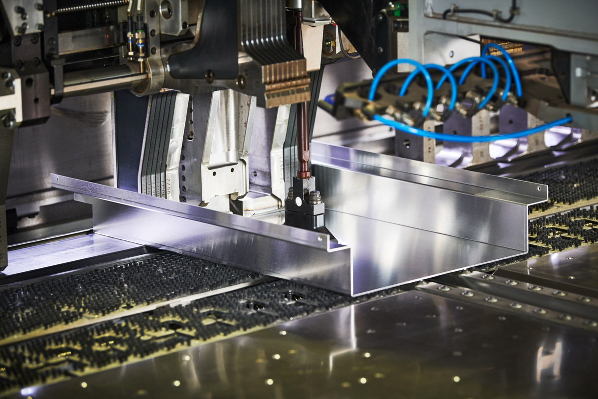 A machine forming metal for a custom building specialties project in El Paso.